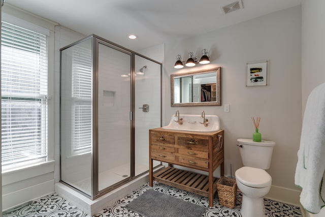 bathroom featuring visible vents, toilet, a shower stall, vanity, and tile patterned floors