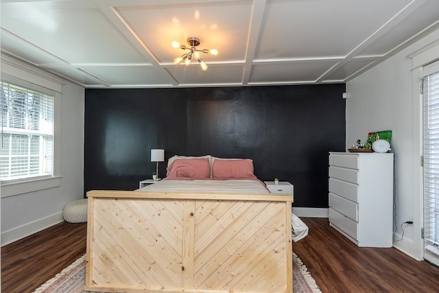 bedroom featuring an accent wall, dark wood-style flooring, coffered ceiling, and baseboards