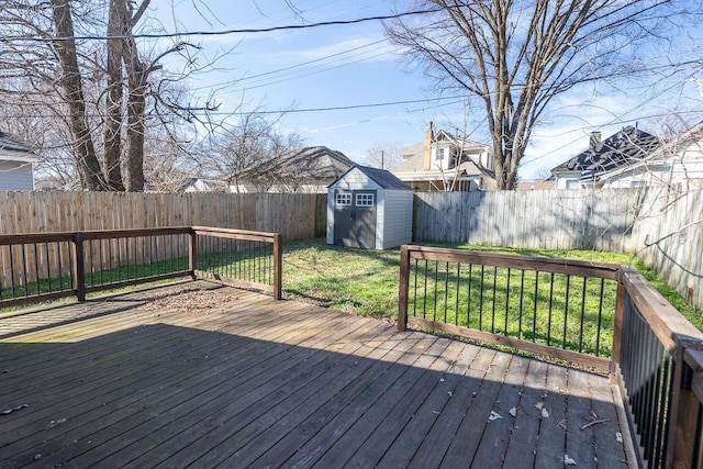 wooden deck featuring a storage shed, a fenced backyard, a yard, and an outdoor structure