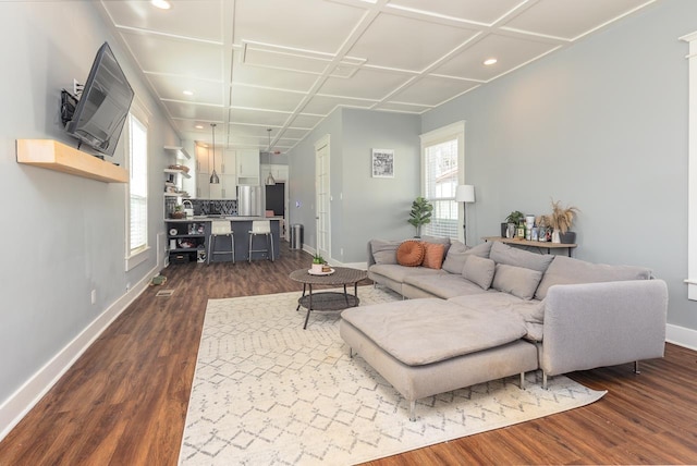 living room featuring baseboards, dark wood finished floors, and a healthy amount of sunlight