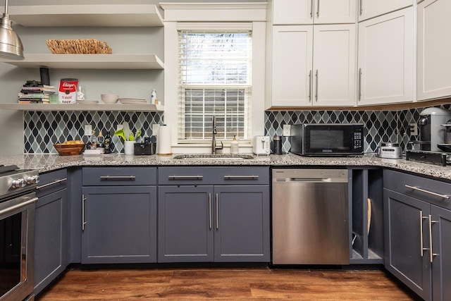 kitchen with open shelves, dark wood-type flooring, stainless steel appliances, and a sink