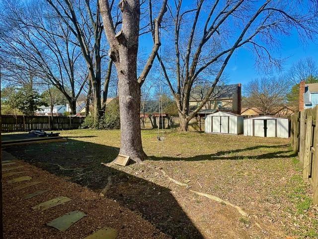 view of yard featuring an outbuilding, a storage unit, and a fenced backyard