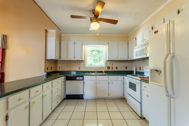 kitchen with white appliances, light tile patterned floors, dark countertops, white cabinetry, and a sink