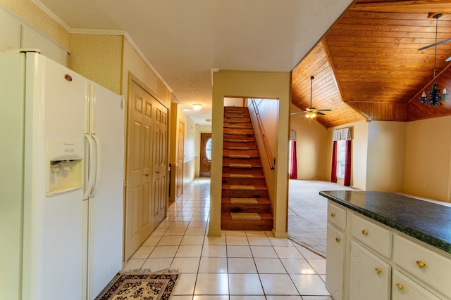 kitchen with light tile patterned floors, wood ceiling, white cabinets, white fridge with ice dispenser, and dark countertops