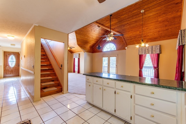 kitchen with light tile patterned floors, dark countertops, wood ceiling, white cabinets, and open floor plan