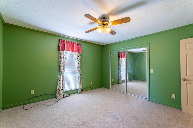 carpeted spare room with a textured ceiling, ceiling fan, and crown molding