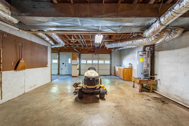 garage featuring concrete block wall and gas water heater