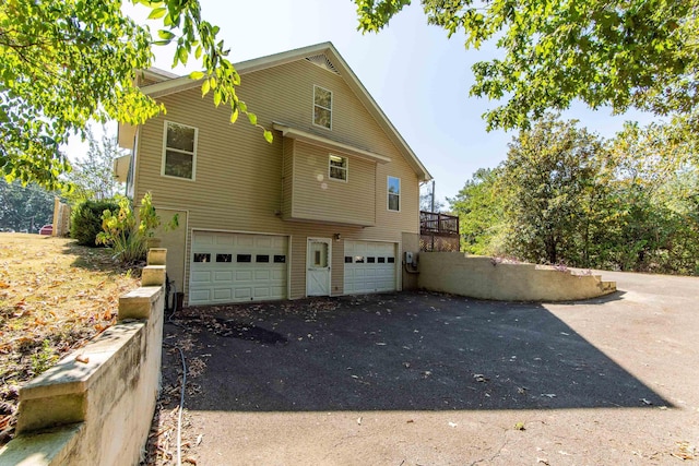 view of home's exterior featuring a garage and aphalt driveway