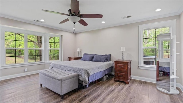 bedroom with recessed lighting, visible vents, ornamental molding, wood finished floors, and baseboards