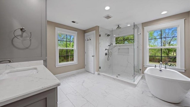 bathroom featuring marble finish floor, a freestanding tub, a marble finish shower, and baseboards