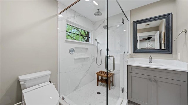 bathroom with toilet, a marble finish shower, and vanity