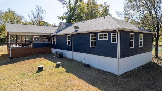 view of side of home featuring a yard, a shingled roof, crawl space, and central air condition unit