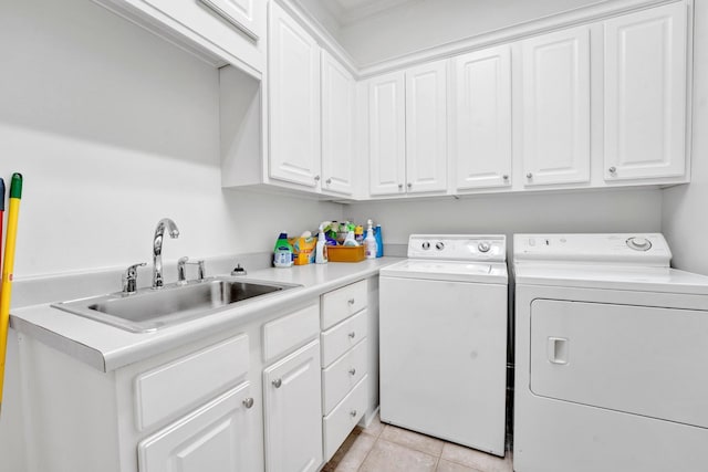 clothes washing area featuring light tile patterned floors, cabinet space, a sink, and separate washer and dryer