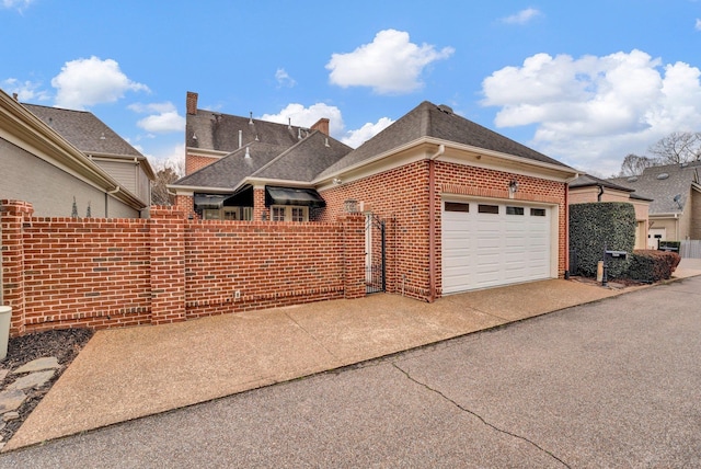 exterior space with driveway, roof with shingles, a garage, and brick siding