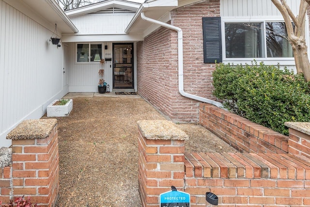 view of exterior entry featuring brick siding