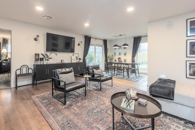 living room with wood-type flooring and recessed lighting