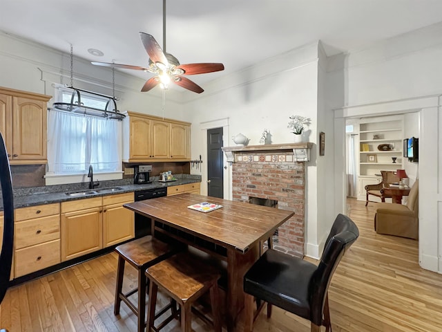 kitchen featuring black dishwasher, light wood-style flooring, ornamental molding, light brown cabinets, and a sink