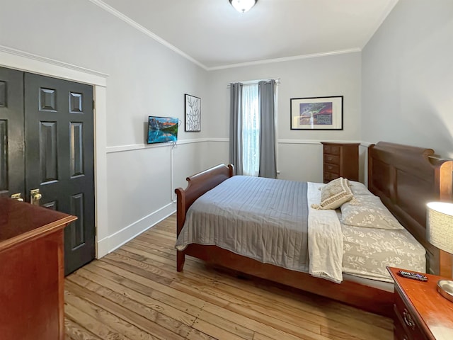 bedroom with ornamental molding and hardwood / wood-style floors