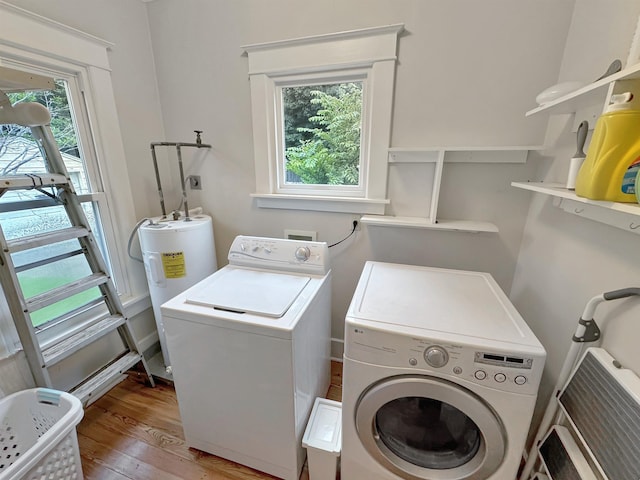 laundry room with laundry area, water heater, a wealth of natural light, and washer and dryer