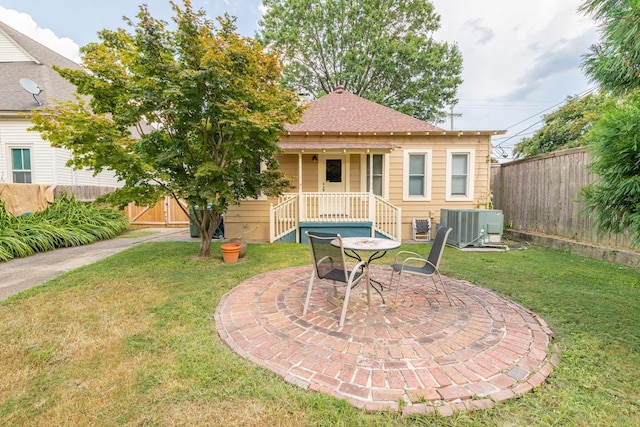 exterior space featuring a front lawn, roof with shingles, central AC unit, and fence