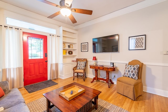 interior space featuring built in features, baseboards, ceiling fan, wood finished floors, and crown molding