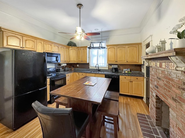 kitchen with light wood-style floors, crown molding, a sink, and black appliances