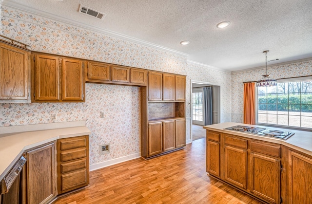 kitchen with brown cabinets, visible vents, stovetop with downdraft, dishwashing machine, and wallpapered walls