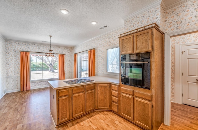 kitchen featuring a textured ceiling, stainless steel stovetop, oven, and wallpapered walls