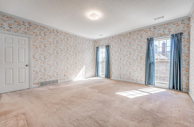 spare room featuring a textured ceiling, visible vents, and wallpapered walls