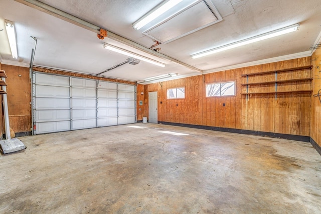 garage featuring a garage door opener and wood walls