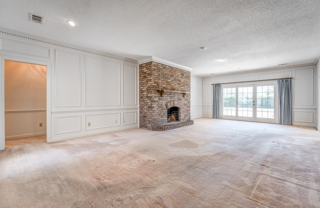 unfurnished living room featuring carpet, visible vents, a decorative wall, and ornamental molding