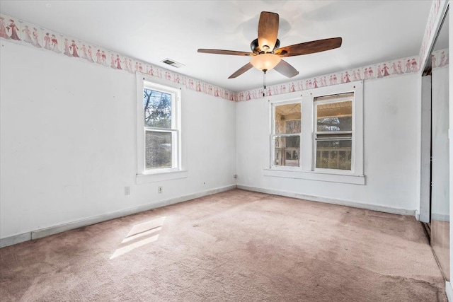 unfurnished room featuring a ceiling fan, carpet, visible vents, and baseboards