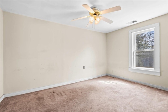 empty room featuring a ceiling fan, baseboards, visible vents, and carpet flooring