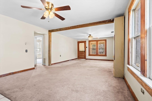 spare room featuring light carpet, ceiling fan, baseboards, and beamed ceiling