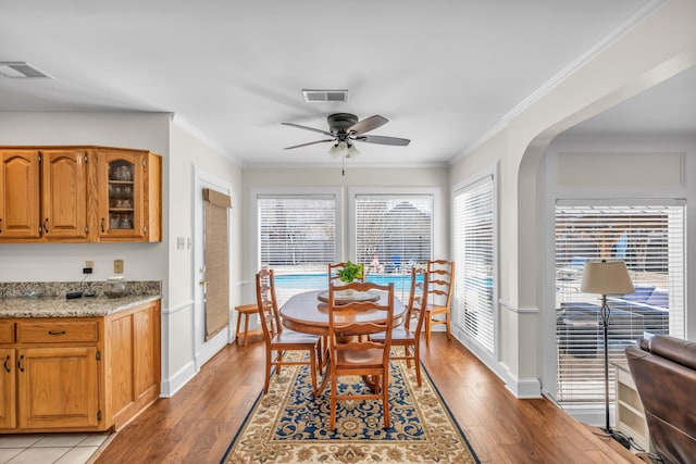 dining space with visible vents, crown molding, and light wood finished floors