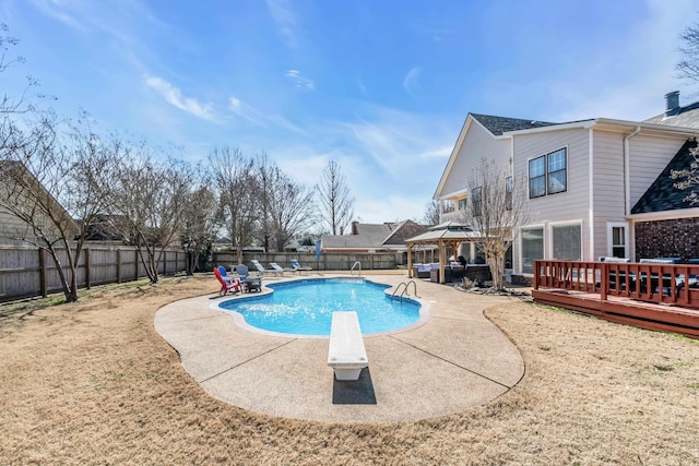 view of swimming pool with a deck, a fenced backyard, a diving board, a fenced in pool, and a patio area