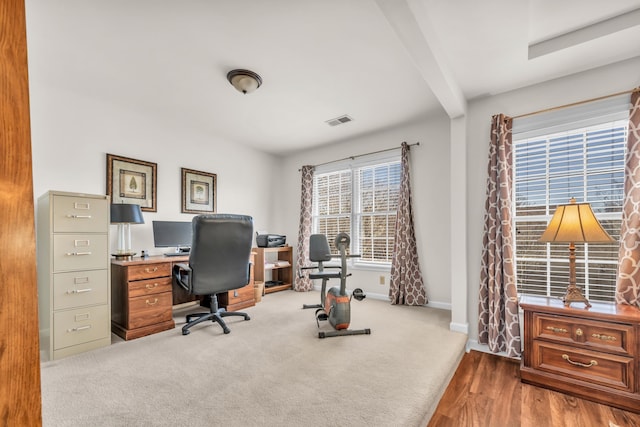 carpeted office featuring baseboards, visible vents, and beamed ceiling