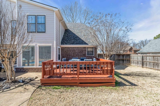 rear view of house featuring a fenced backyard, brick siding, a shingled roof, a yard, and a wooden deck