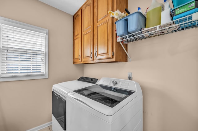 clothes washing area featuring cabinet space, baseboards, and separate washer and dryer