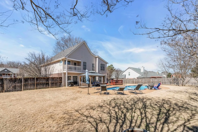 back of house with a fenced backyard, a patio, a fenced in pool, and a gazebo