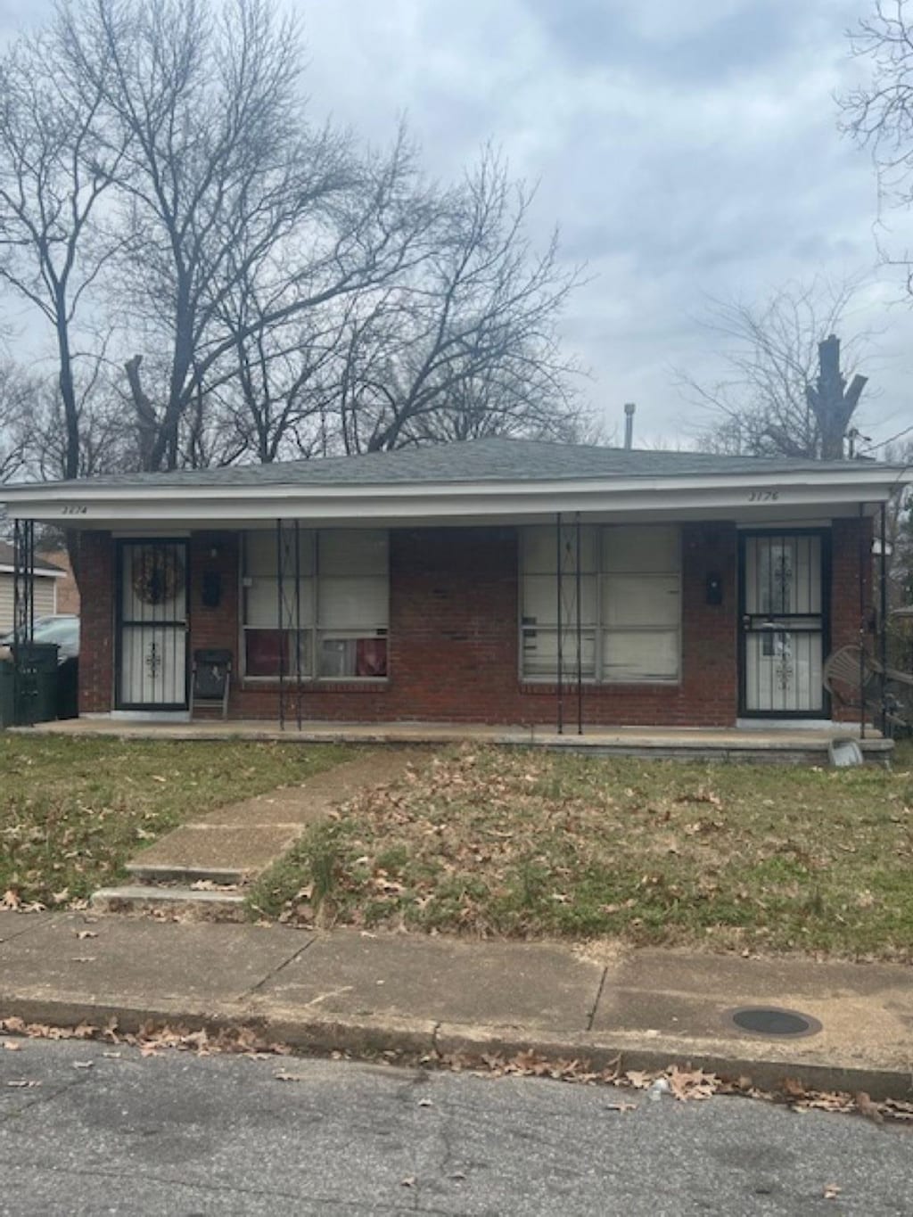 view of front of home with a porch and brick siding