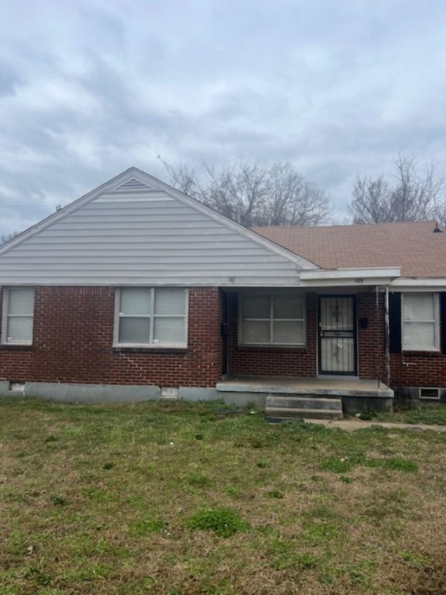 view of front of property with a front yard and brick siding