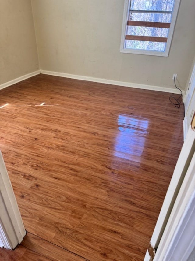 unfurnished room featuring baseboards and wood finished floors