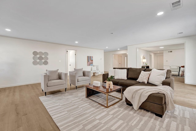 living room featuring light wood-style floors, baseboards, visible vents, and recessed lighting