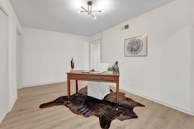 office with baseboards, a notable chandelier, visible vents, and wood finished floors