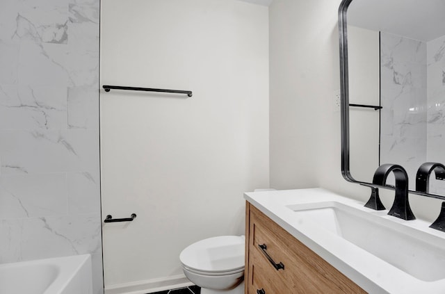 bathroom with toilet, vanity, and baseboards