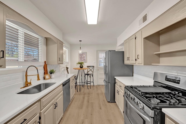 kitchen featuring light countertops, visible vents, appliances with stainless steel finishes, a sink, and light wood-type flooring