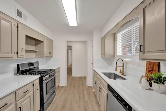 kitchen with light countertops, visible vents, light wood-style flooring, appliances with stainless steel finishes, and a sink