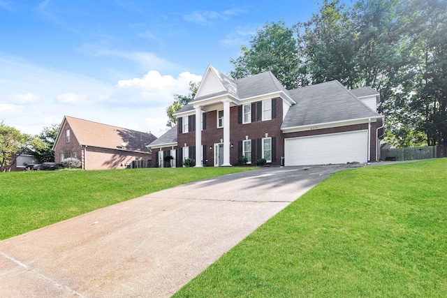 neoclassical / greek revival house featuring a garage, driveway, brick siding, and a front lawn