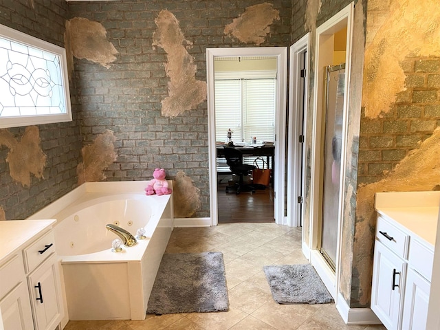 full bath with brick wall, a tub with jets, a stall shower, and vanity